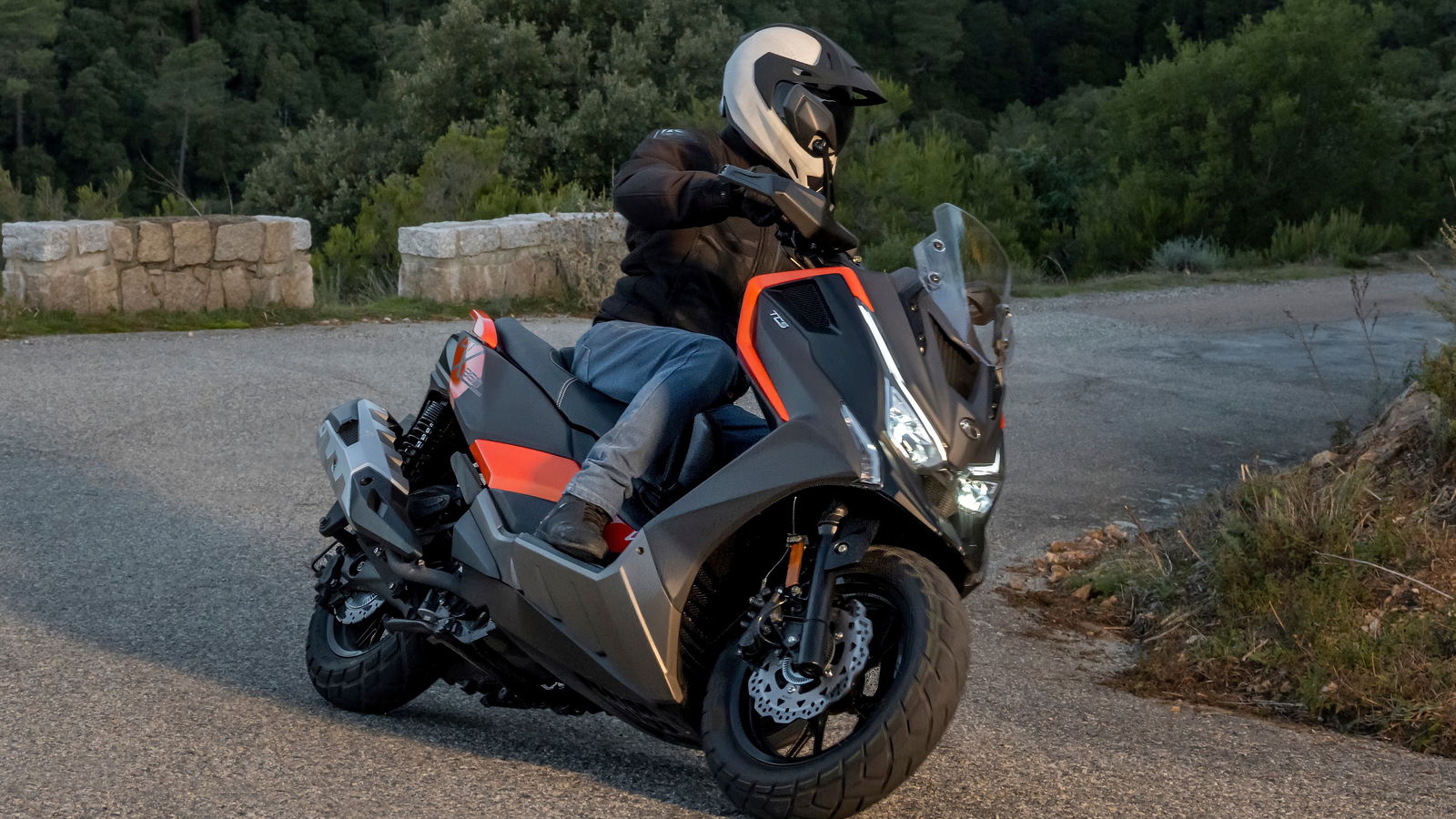 a maxi scooter rides upo a mountain road